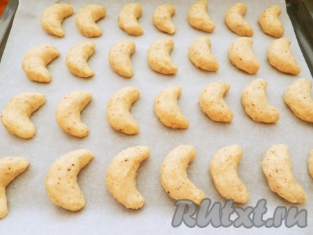 Противень застелить бумагой для выпечки. Тесто набирать чайной ложкой и руками формовать печенье в виде небольших полумесяцев.