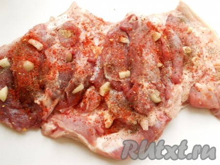 Кухонным молоточком немного отбить мясо. Чеснок очистить и порезать кусочками. Нашпиговать чесноком рульку, посыпать солью, специями и паприкой. Свернуть рульку, поместить в пакет и отправить для маринования в холодильник часов на 12. Обычно я подготавливаю свиную рульку вечером, а готовлю к обеду.