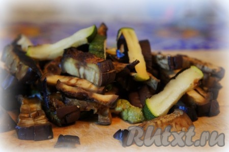 Баклажаны и кабачки помыть, нарезать на полоски и выложить на противень, застеленный бумагой для выпечки. Поставить противень в хорошо прогретую духовку. Запекать баклажаны и кабачки при температуре 180 градусов до готовности. Готовность можно определить вилкой, если овощи легко прокалываются, значит они готовы. Кабачки запекаются примерно 25-30 минут, баклажаны вытаскиваем минут через 35-40. Но обязательно проверяйте овощи на готовность, продолжительность запекания во многом зависит от толщины нарезки и сорта овощей. Запечённые баклажаны и кабачки достать из духовки, дать немного остыть, нарезать на небольшие брусочки. Остывшие нарезанные овощи переложить в миску.