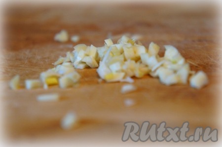 Чеснок мелко нарезать и добавить к овощам.