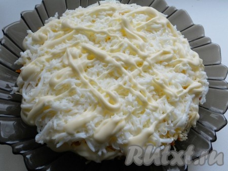 Яйца почистить, отделить желтки от белков. Натереть белки на мелкой тёрке и выложить четвертым слоем. Смазать немного майонезом.