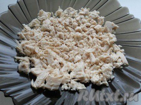 Куриное филе отварить до готовности в подсоленной воде (в течение 25-30 минут с момента закипания воды). Отварить яйца в течение 10 минут после закипания воды. Варёное куриное мясо и яйца остудить. Нарезать варёное мясо курицы на небольшие кусочки, выложить первым слоем в салатник с достаточно плоским дном.