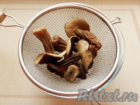 Сухие грибы промыть, замочить на ночь в чистой холодной воде. Воду слить, залить грибы свежей водой и отварить в течение 1 часа. Откинуть грибы на сито, бульон сохранить.