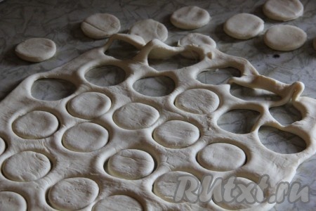 Заранее разморозить слоёное тесто. Для волованов можно брать и дрожжевое, и бездрожжевое тесто - это не принципиально. У меня слоёное тесто было из одного длинного пласта, который я разделила на 2 равные части. Обе части слоёного теста на присыпанной мукой поверхности раскатать в пласт толщиной 3 мм. Из первой части теста рюмочкой (или специальной формой) выдавить кружочки.