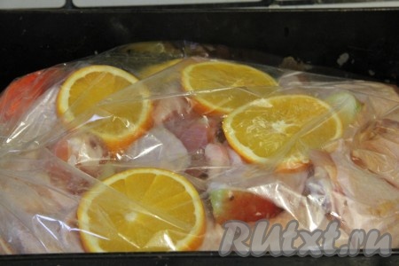 Апельсины нарезать кружочками и выложить на курицу.