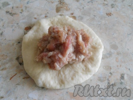 Далее каждый шарик теста растянуть руками в небольшую лепёшку, в центр поместить начинку из фарша (я выкладывала на каждую лепёшку примерно 44 грамма фарша).