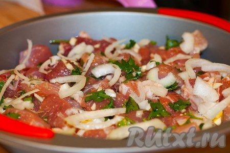 Нарежьте репчатый лук полукольцами и выложите поверх мяса.