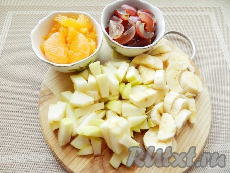 Мандарины очистить, разделить на дольки и очистить от пленочек. Виноградины разрезать на четвертинки, удалить косточки. Яблоко очистить от кожуры, нарезать небольшими кусочками, удалив сердцевину. Очистить и нарезать банан.
