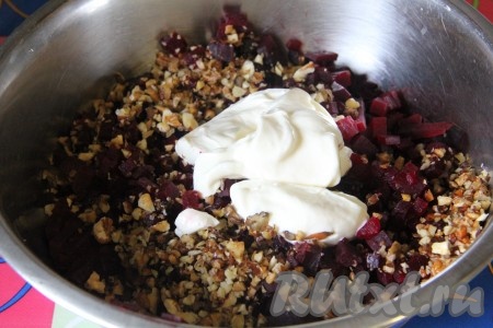 Чеснок выдавить, смешать с майонезом и добавить к свекле следом за орехами.
