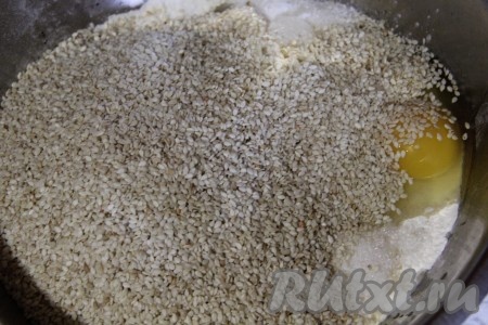 Соединить в глубокой миске яйца, кунжутные семечки, растительное масло, лимонный сок, сахар, разрыхлитель и 1 стакан муки, перемешать.
