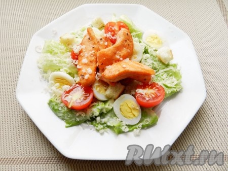 Добавить сухарики, обжаренный лосось, еще немного присыпать сыром.