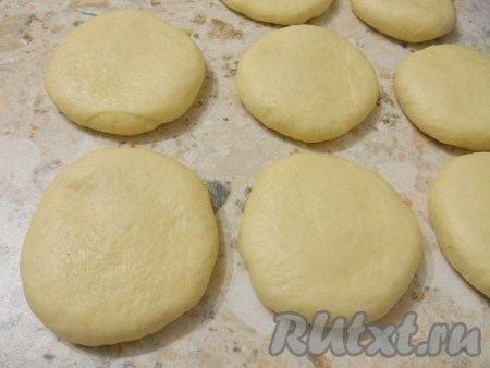 Шарики теста раскатать скалкой в небольшие лепешки, снова накрыть пищевой пленкой и оставить в теплом месте на 30-40 минут.