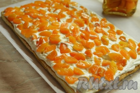 Остывший миндальный рулет развернуть и равномерно нанести крем, сверху разложить нарезанные ломтиками фрукты.
