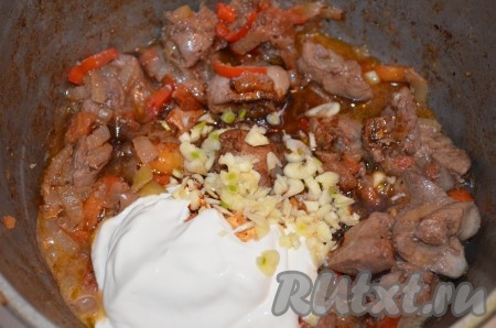 Тушить куриную печень с овощами 5-7 минут, помешивая, то есть почти до готовности. Затем добавить сметану, рубленный чеснок и соевый соус. Перемешать, дать закипеть и огонь выключить. Посыпать рубленной зеленью.
