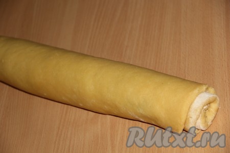  Свернуть пласт с начинкой в плотный рулет, начиная с широкой стороны. 