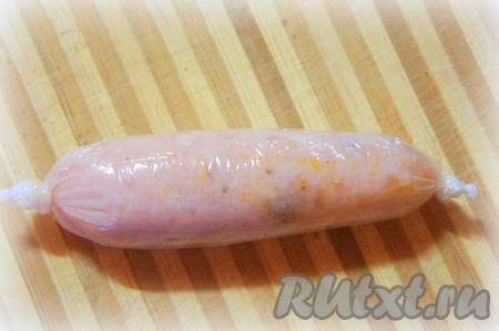 Сверните фарш с помощью плёнки, сформировав сосиску. Один конец плотно завяжите, подтолкните аккуратно к нему фарш, выпустив оставшийся под плёнкой воздух, и завяжите другой конец плёнки.
