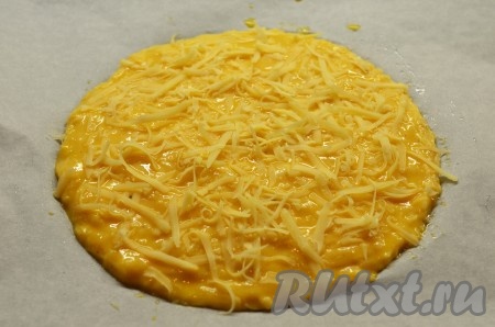 Выложите противень промасленной пергаментной бумагой и наметьте круг размером 23 см. Ложкой выложите тесто вдоль внутренней части круга, размеченного на кулинарной бумаге. Смажьте тесто взбитым яйцом и посыпьте оставшимся сыром. Выпекайте 25-30 минут (или до золотистого цвета)&nbsp;в разогретой до 220 градусов&nbsp;духовке.
