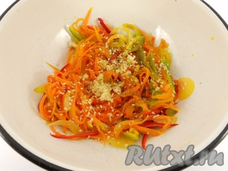 Переложить овощи в миску, добавить чеснок, пропущенный через пресс, сахар, уксус, кунжут и специи (в качестве специй я добавила 0,5 чайной ложки кориандра и красный молотый перец, регулируя перцем остроту блюда по своему вкусу).