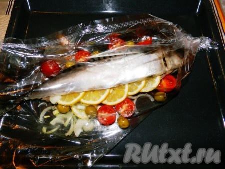 Рукав для запекания завязать с одной стороны. Выложить в рукав оставшийся лук и лимон, сверху положить скумбрию. Добавить к рыбе разрезанные пополам помидоры черри и оливки.