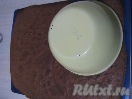 После того как корж готов, мы аккуратно его выкладываем на стол вместе с бумагой. Берём чашку&nbsp;объемом 1,5 литра и с краю коржа вырезаем круг.
