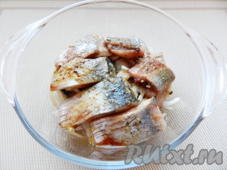 Филе сельди нарезать на порционные кусочки. В стеклянную ёмкость выложить кусочки сельди и лук, залить маринадом.