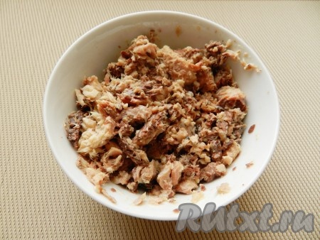 Из банки с рыбными консервами слить масло, размять рыбу вилкой.