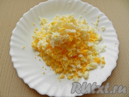 Яйца заранее отварить вкрутую (варить 9-10 минут с момента закипания), остудить и очистить. Натереть яйца на средней тёрке.