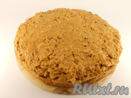 Тщательно перемешать ложкой получившийся крем с крекером и арахисом. Теперь приступаем к сборке торта "Сникерс". Выложить одну часть бисквита на плоскую тарелку. Поверх бисквита выложить весь крем с орехами и крекером, сверху поместить вторую часть бисквита, чуть придавить. Поставить торт в холодильник на несколько часов для того, чтобы крем застыл.