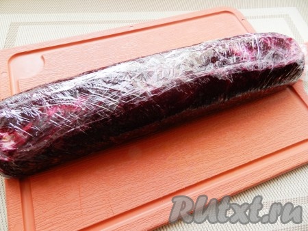 Аккуратно поднять края плёнки с двух длинных сторон к середине, формируя таким образом рулет. Рулет немного прижать сверху и завернуть в плёнку. В таком виде убрать рулет "Сельдь под шубой" в холодильник на несколько часов или на ночь, чтобы он хорошо пропитался.