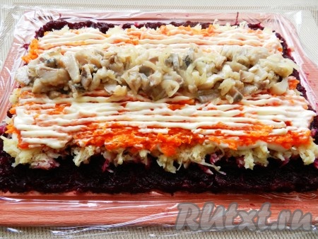 По центру выложить нарезанную селёдку. Поверх селёдки разложить тонко нарезанный лук.