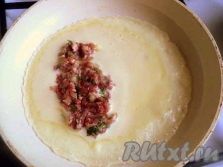 Нагреть сковородку, смазать маслом, налить тесто, чтобы получился нетолстый блинчик. Сразу же, пока блин не схватился, выложить 1 столовую ложку фарша на одну сторону блина, оставив свободными края.
