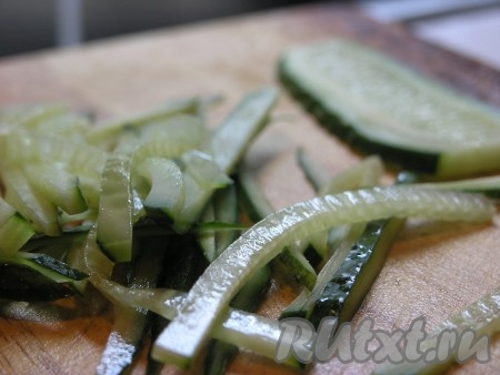 Огурцы нарезаем тонкими полосками по 0,5 см толщиной.