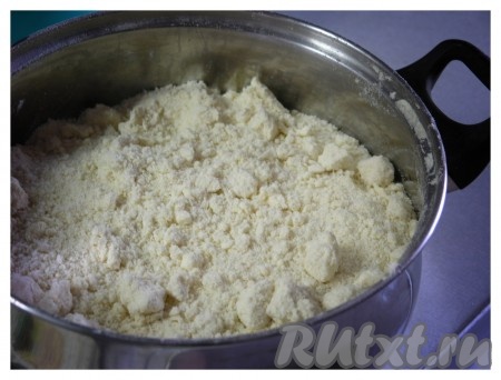 В другой глубокой миске (или объёмной кастрюле) смешать просеянную муку, разрыхлитель и сахар, добавить натёртое на тёрке сливочное масло (или маргарин), перетереть руками до получения сыпучей крошки.