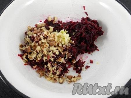 Свеклу натереть, добавить 2 зубчика чеснока, пропущенного через пресс и половину измельченных орехов. Хорошенько перемешать.
