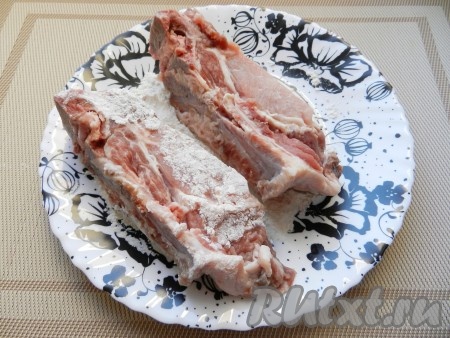 Свиные рёбра разрезать по кости и присолить. Затем каждое рёбрышко обвалять в муке со всех сторон.