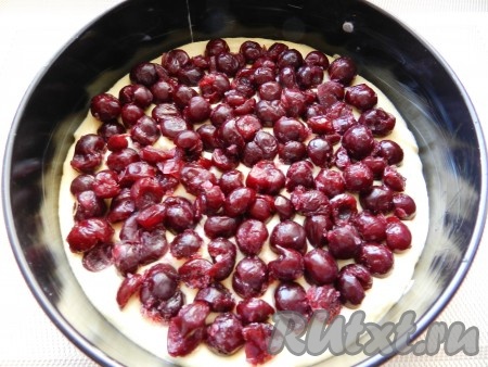 Поверх теста разложить в один слой вишню без косточек. Если вы готовите с замороженной вишней, тогда заранее полностью разморозьте её, выделившуюся жидкость слейте.