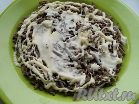 Остывшую печень натереть на крупной тёрке и выложить поверх лука. Посолить, посыпать смесью перцев. Смазать майонезом.