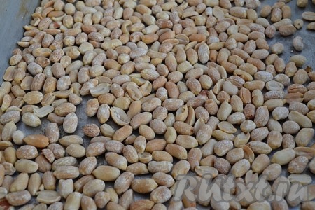 Готовый чизкейк достать из духовки, оставить остывать. Эту выпечку после полного остывания можно подавать к столу. Но я решила украсить её варёной сгущёнкой и орехами. Пока пирог остывает, нужно орехи (у меня - арахис) выложить в форму для выпечки, застеленную пергаментом, в один слой, отправить в духовку, разогретую до 180 градусов, на 5 минут. Проверять на готовность, если не совсем достаточно обжарились, запекайте орехи ещё 1 или 2 минуты. Будьте осторожны, чтобы орехи не сгорели! Достаньте их из духовки и остудите.