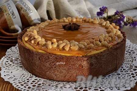 Нагреть мёд на водяной бане, пока он не станет жидким. Сразу добавить орехи в мёд и быстро перемешать так, чтобы орехи полностью покрылись мёдом.&nbsp;После этого разложить орехи на листе для выпечки так, чтобы можно было отлепить орехи друг от друга. Необходимо это сделать быстро. Остывший чизкейк с творогом из песочного теста сверху покрыть варёным сгущённым молоком и украсить орехами, которые мы покрыли мёдом.