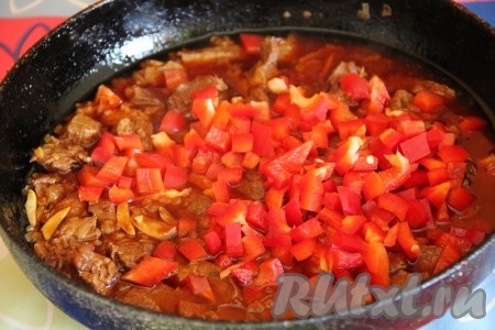 По истечении времени добавить к мясу болгарский перец, нарезанный кубиками.

