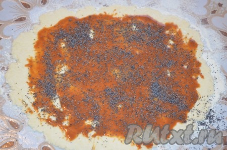 Немного отступив от краёв, смазываем тесто 2-2,5 столовыми ложками варёной сгущёнки, по желанию, посыпаем маком.