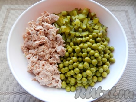 Нарезать солёные (или маринованные) огурцы на кубики такого же размера, как были нарезаны варёные овощи и яйца. С тунца слить всю лишнюю жидкость, размять рыбу вилкой. В миску с нарезанными овощами и яйцами добавить огурцы, тунца и горошек без жидкости.