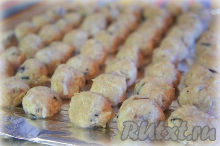 Влажными руками сформовать небольшие рыбные тефтели и выложить их на небольшом расстоянии друг от друга на разделочную доску, предварительно застеленную фольгой (или пищевой плёнкой).