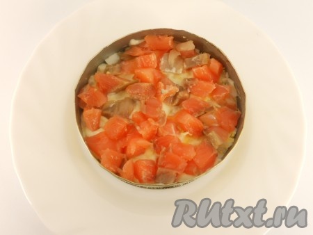 Далее, расположить четвертым слоем порезанную небольшими кусочками соленую красную рыбку (также, половину нормы).