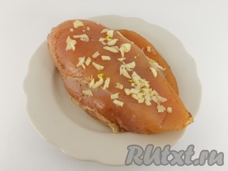 Чеснок измельчить и натереть им куриное филе.
