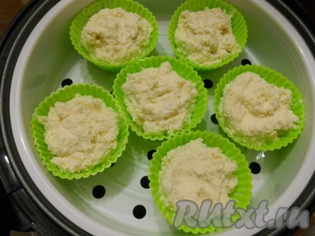 Поместить силиконовые формочки с тестом в чашу мультиварки для готовки на пару. Влить воду в нижнюю чашу мультиварки, на неё поставить чашу с формочками, крышку закрыть. Готовить сырники из творога на режиме "На пару" 30 минут.