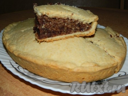 Наивкуснейший песочный пирог с начинкой с орехами и шоколадом немного остудить, после этого переложить из формы на тарелку, дать ему остыть. А затем нарезать на части и подать к столу. В этой выпечке настолько интересная начинка, что хочется наслаждаться её вкусом снова и снова.