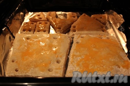 Из раскатанного теста вырезаем две стенки, один большой треугольник, один треугольник с отверстием в виде двери, два маленьких прямоугольника, два маленьких треугольника (как на фото) и прокалываем дырочки, как показано на рисунке. 
