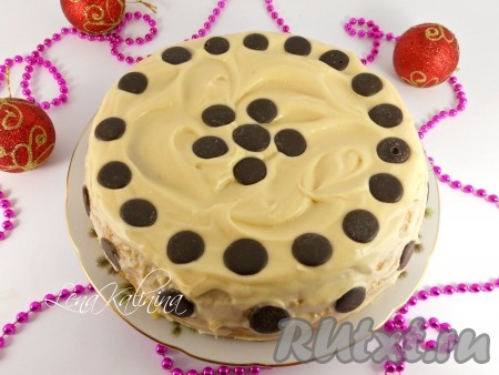 Накрыть вторым коржом, чуть придавить. Верх и бока бисквита также хорошо смазать кремом. Украсить торт шоколадными каплями. Поместить в холодильник на 1-1,5 часа (до полного застывания крема).