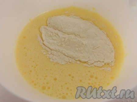 Взбить яйца с сахаром с помощью миксера до пышной, светлой массы (на взбивание потребуется минут 5-6). Отдельно муку смешать с разрыхлителем и просеять. Всыпать мучную смесь во взбитую яичную массу, перемешать на низкой скорости миксера до однородности теста. Добавить растительное масло. Частями тонкой струйкой влить кипяток, непрерывно перемешивая тесто миксером. Тесто для бисквита должно получиться однородным, напоминающим жидкую сметану.